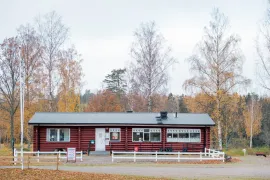 Långsträckt röd timmerstuga vid Fiskeboda Camping.